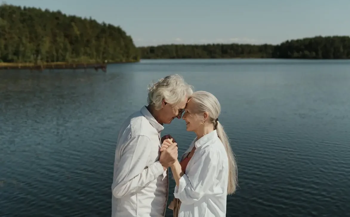 Couple de retraités au bord d’un lac, illustrant la sérénité d’une retraite prolongée à l’étranger.
