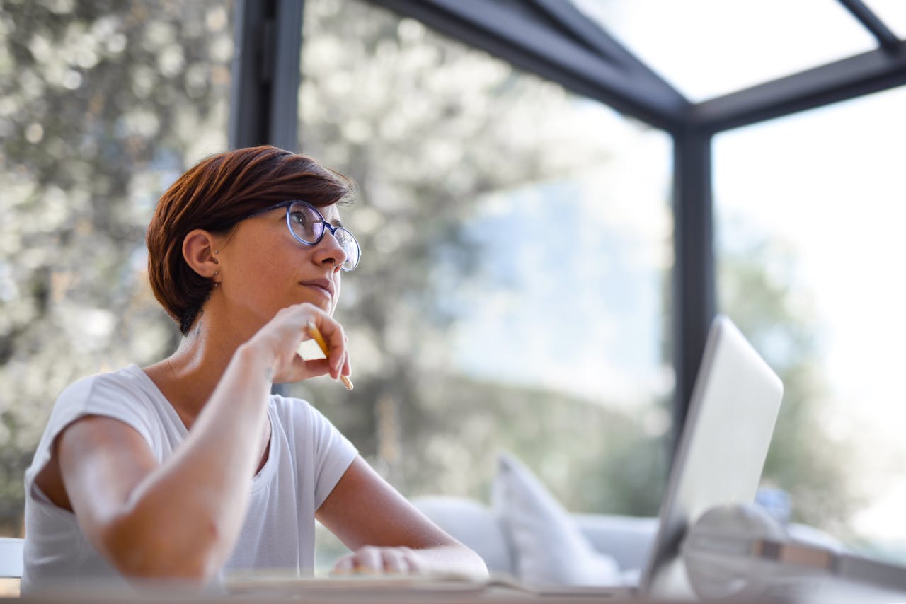 Femme en pleine réflexion, illustrant les questions sur les frais d’un contrat d’assurance-vie et leur impact sur l’épargne.