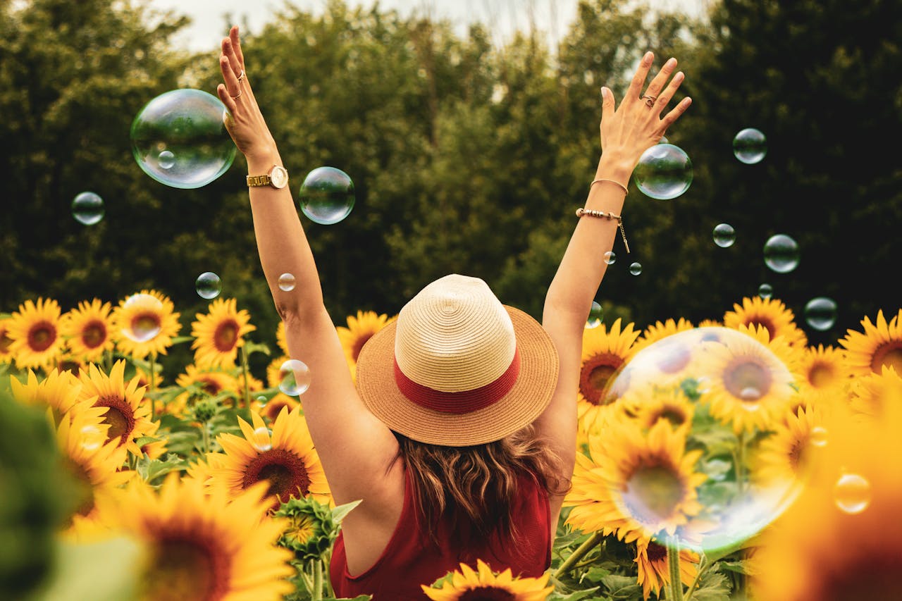Femme entourée de tournesols, symbolisant la croissance et la prospérité financière d’un investissement réussi en 2025.