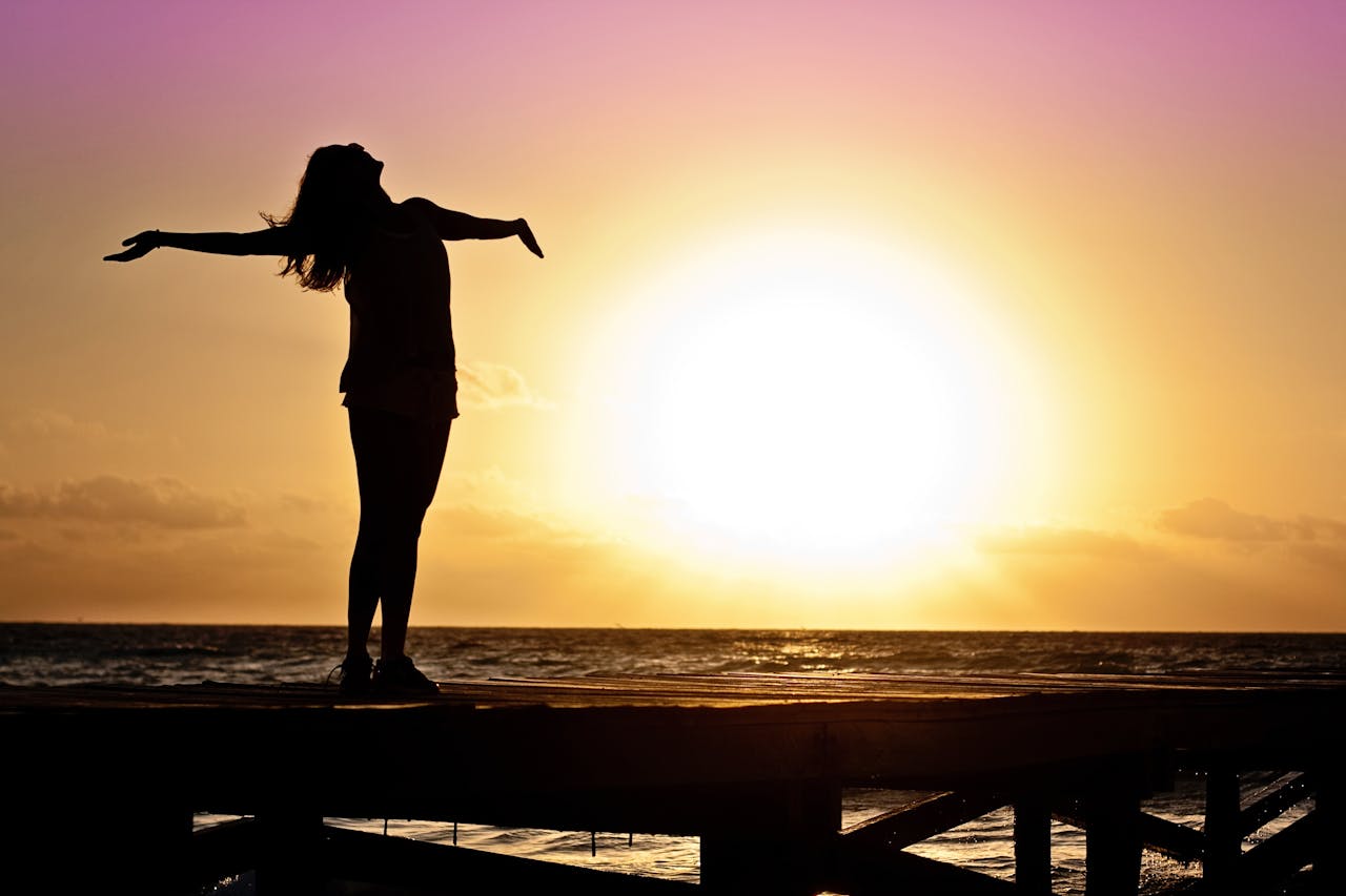 Silhouette d’une femme face au coucher de soleil, symbolisant la vision et la stratégie pour investir 50 000 euros intelligemment.