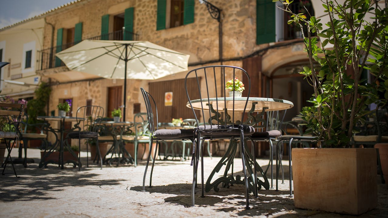 Terrasse ensoleillée avec table et chaises typiques d’Espagne, évoquant la douceur de vivre pour les retraités expatriés.