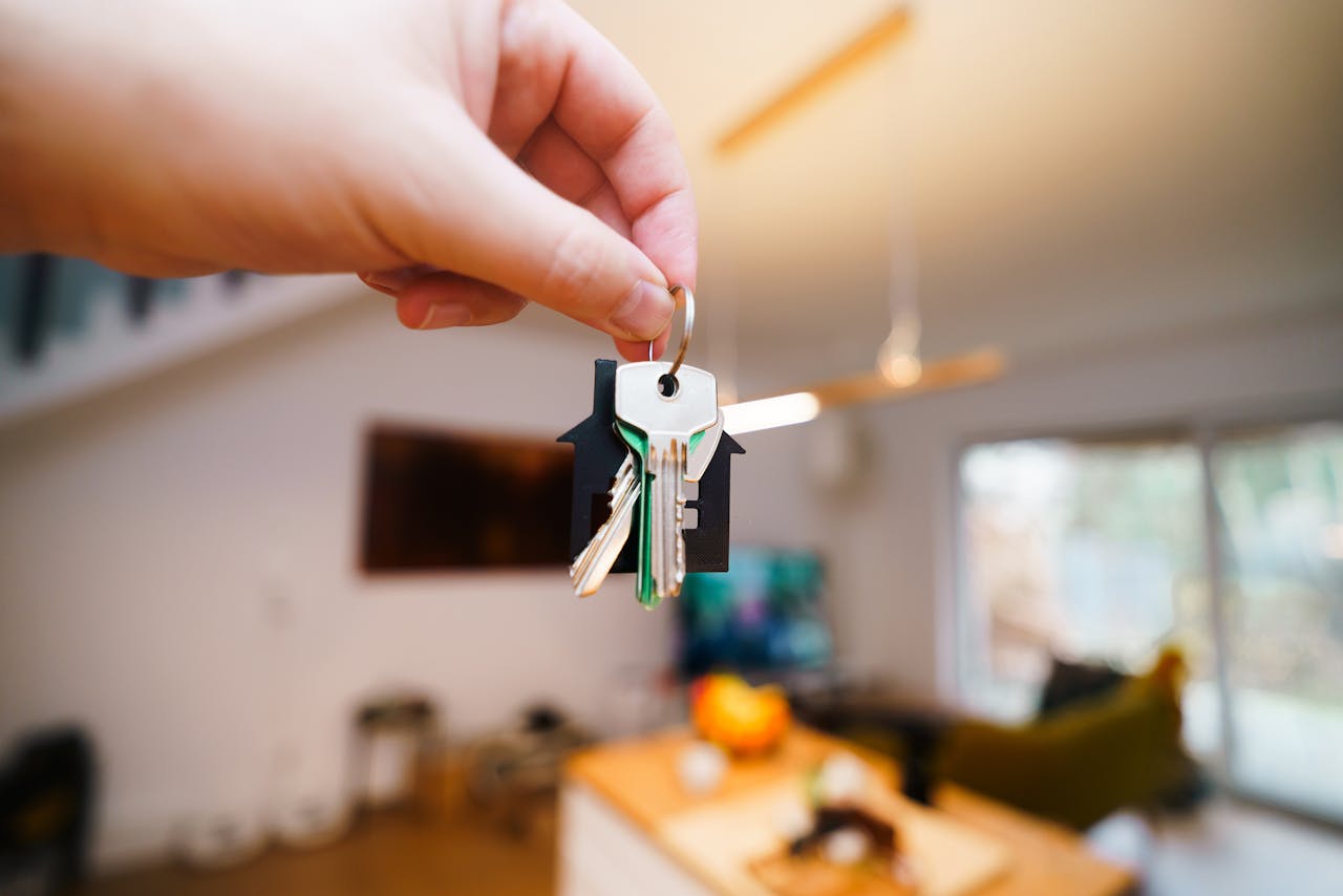 Main tenant des clés dans un intérieur moderne, illustrant la gestion locative à distance d’un bien immobilier.