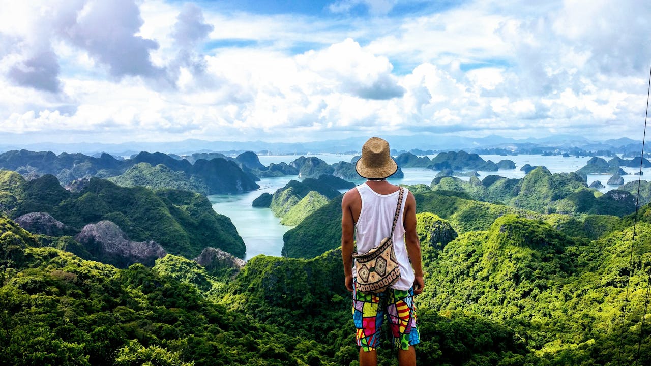 Homme face à la baie d'Ha Long u Vietnam, illustrant la liberté et la sérénité d’une retraite en Asie du Sud-Est.