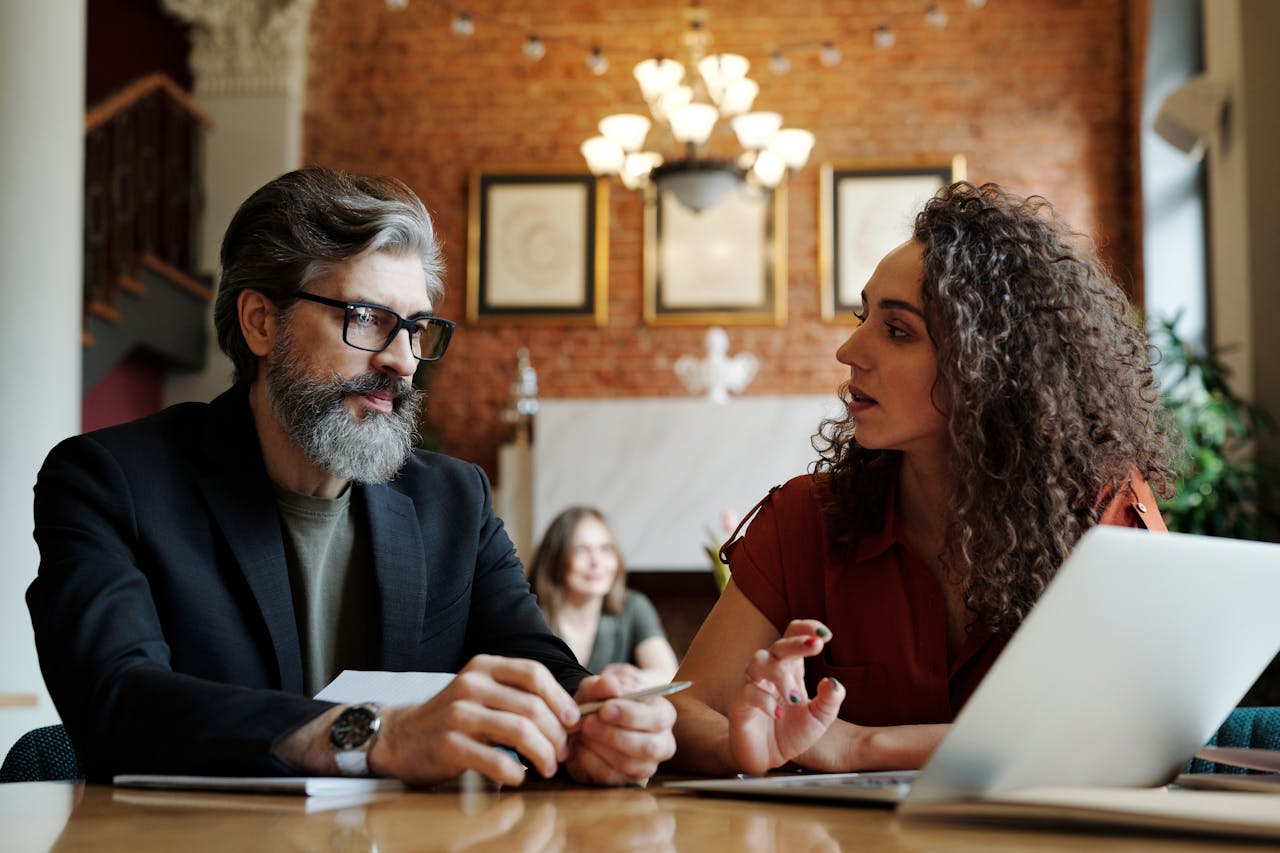 Homme en costume discutant avec une femme, illustrant la gestion et la diversification d’une assurance vie multisupport.
