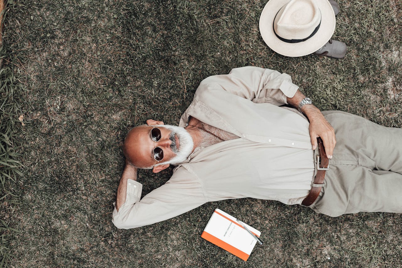 Homme senior assis dans l’herbe, symbole de sérénité et d’anticipation pour la pension de réversion des expatriés en 2025.