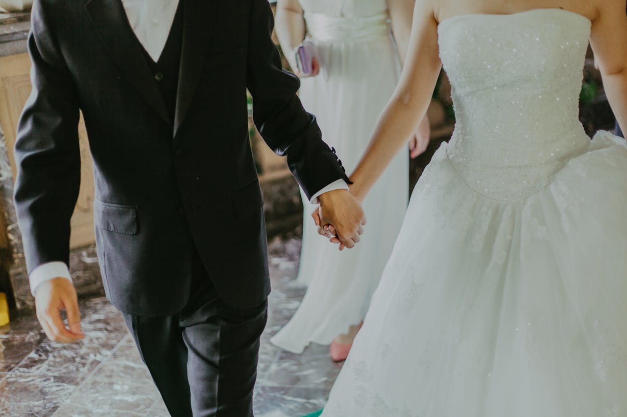 Couple en tenue de mariage marchant main dans la main, illustrant le mariage célébré depuis l’étranger et ses démarches administratives.