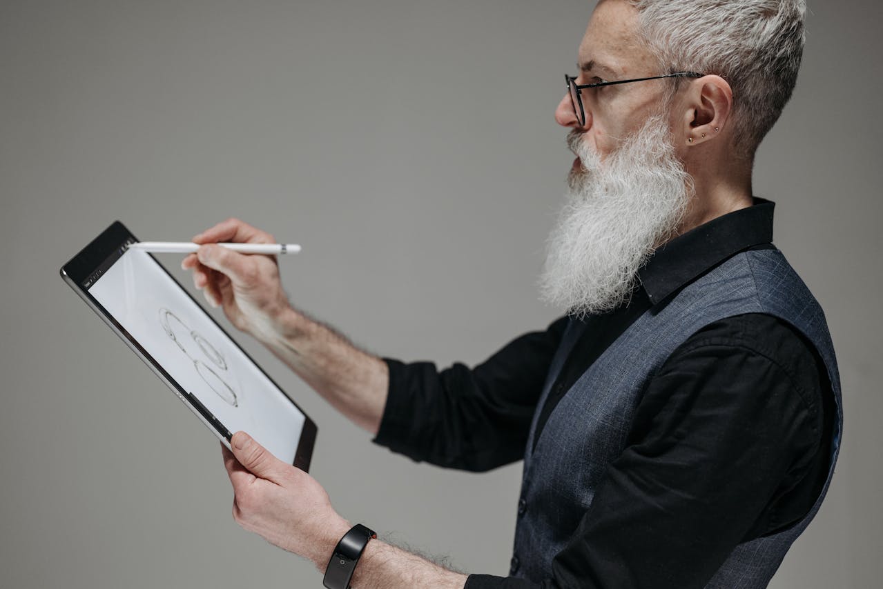 Homme barbu en costume utilisant une tablette, illustrant la réflexion sur l’éligibilité des expatriés à la retraite progressive.