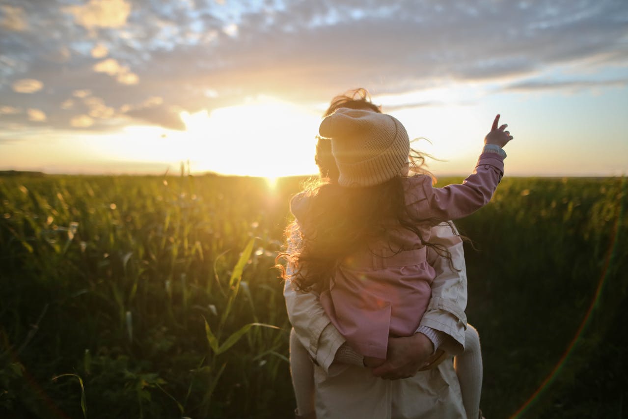 Mère et fille assises sur l’herbe, symbolisant la transmission du patrimoine et la succession internationale d’un contrat de capitalisation.