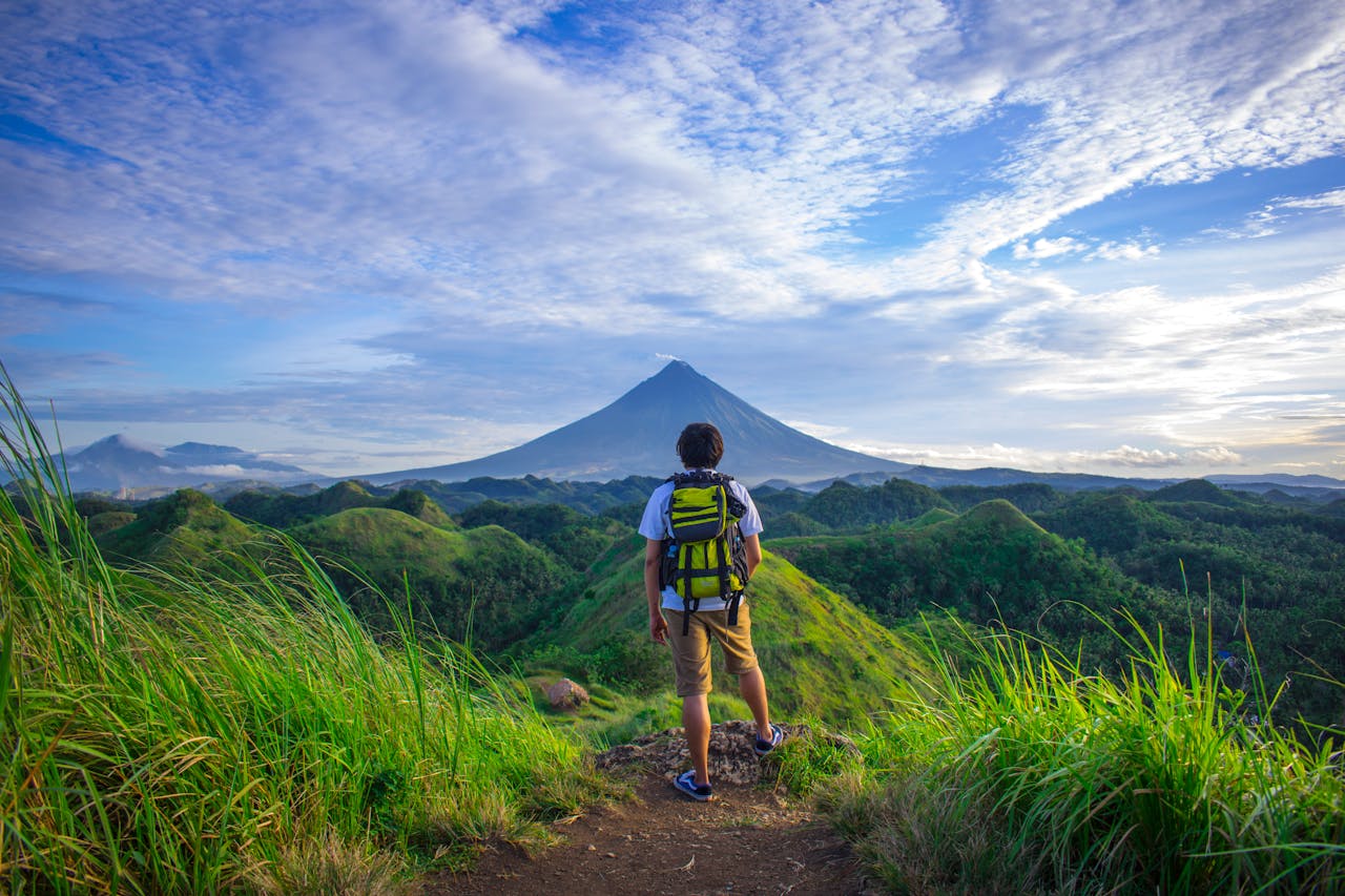 Homme observant un paysage naturel aux Philippines, illustrant l’expatriation et la réflexion sur le choix d’une assurance vie adaptée.