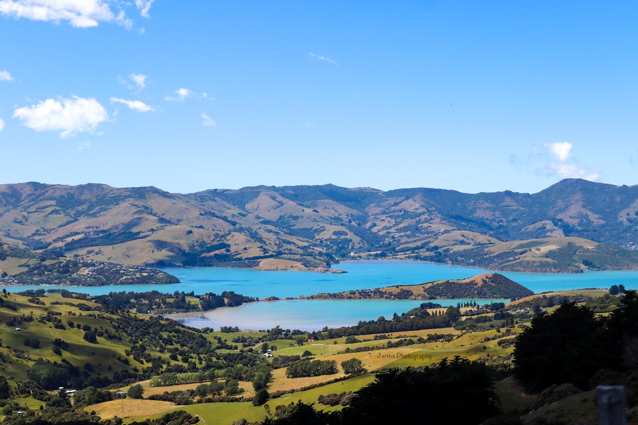 Vue aérienne du port d’Akaroa en Nouvelle-Zélande, illustrant l’expatriation et le choix d’une assurance vie adaptée aux résidents français.