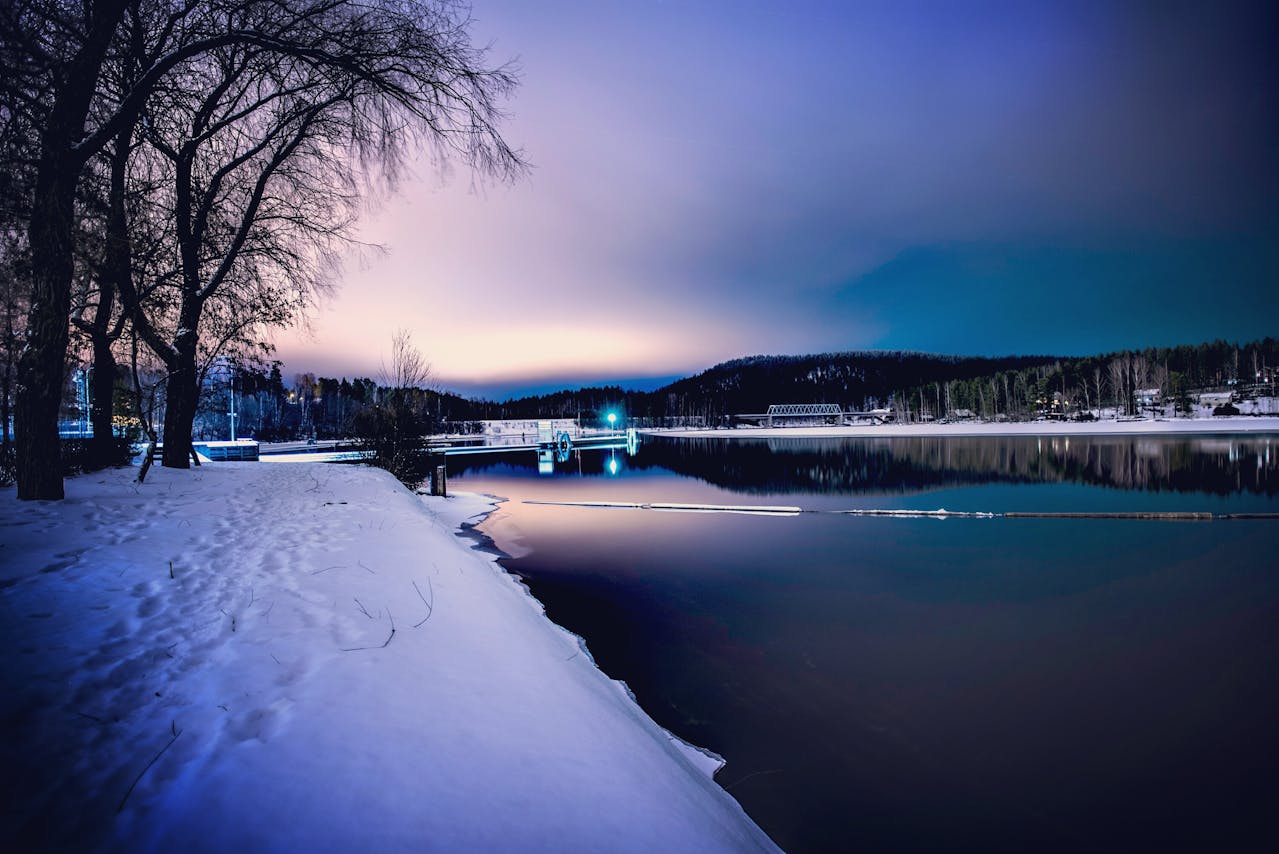 Paysage naturel en Finlande sous un ciel nocturne avec aurores boréales, illustrant l’expatriation et le choix d’une assurance vie adaptée.
