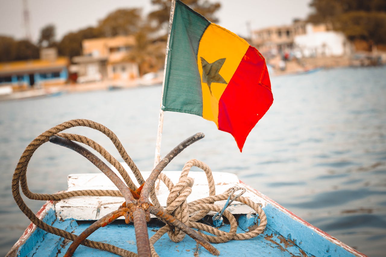 Drapeau du Sénégal flottant sur un bateau, illustrant l’expatriation et la gestion patrimoniale des expatriés français au Sénégal.