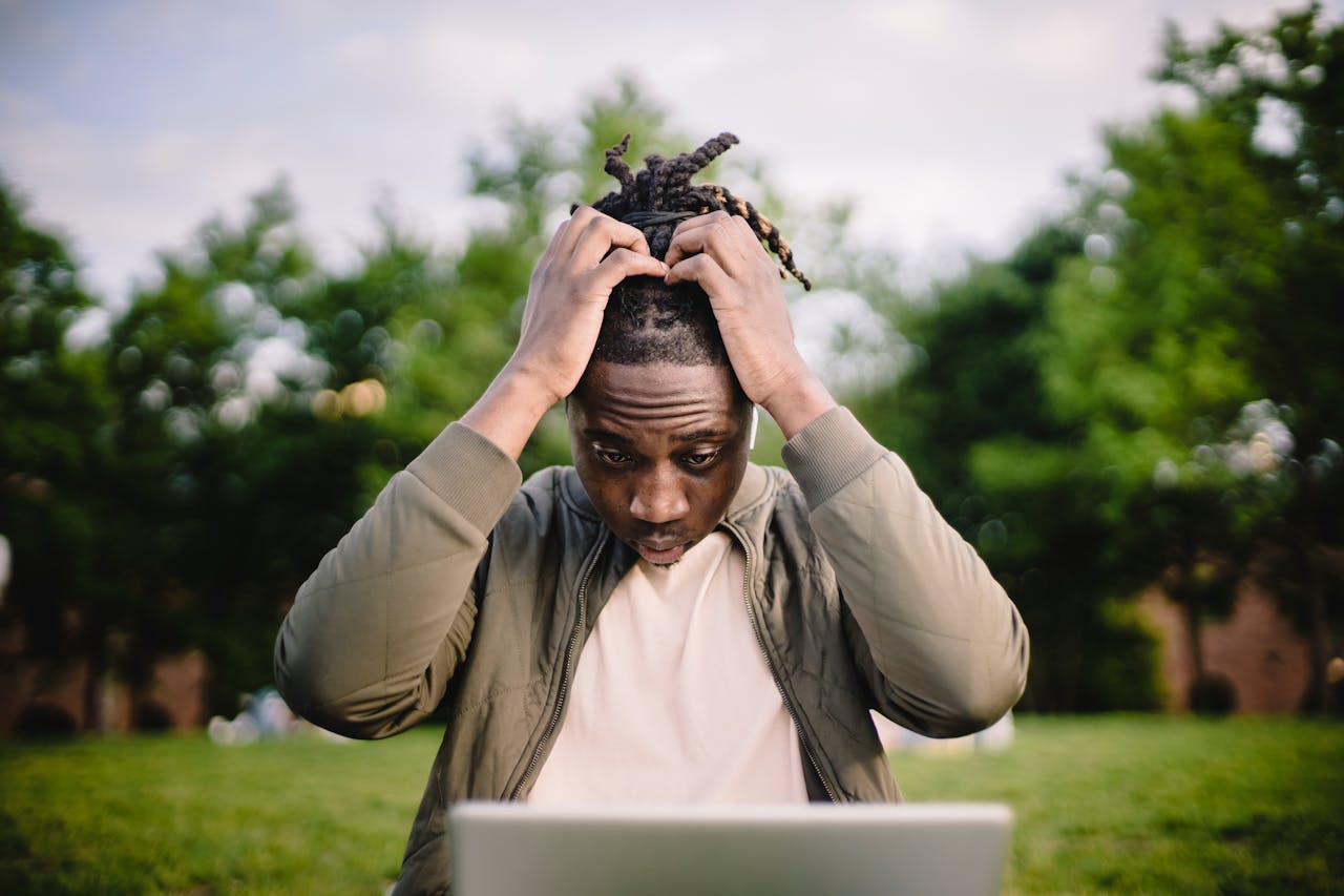 Homme stressé devant son ordinateur portable, illustrant les erreurs patrimoniales coûteuses à éviter pour les expatriés.