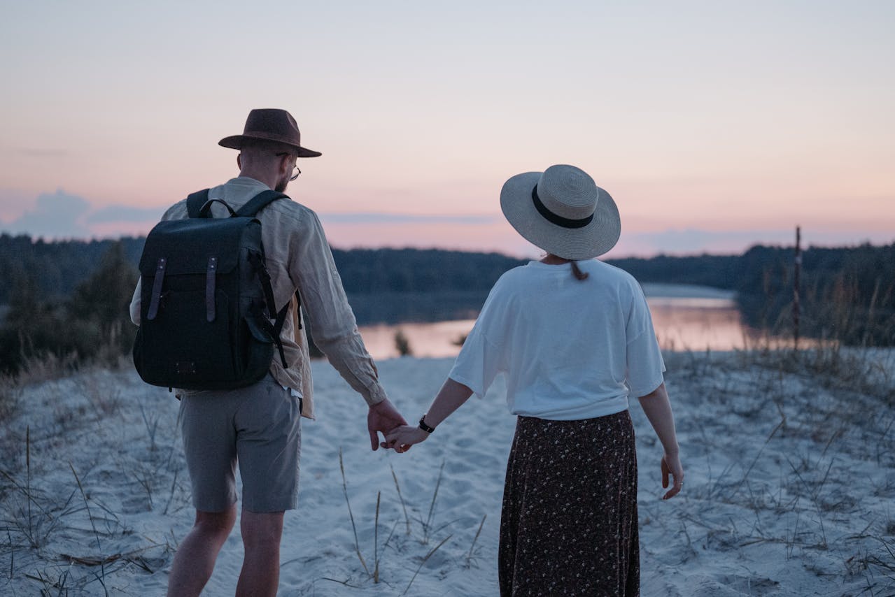 Couple marchant main dans la main sur une plage, illustrant la préparation de la retraite à l’étranger et les choix de placements.