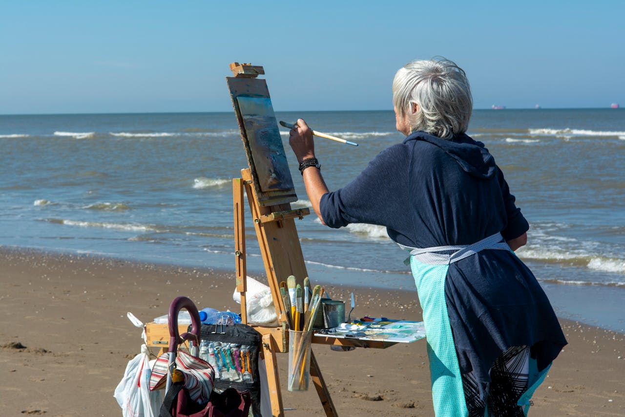 Femme senior peignant face à la mer pour illustrer la rente viagère en assurance-vie luxembourgeoise
