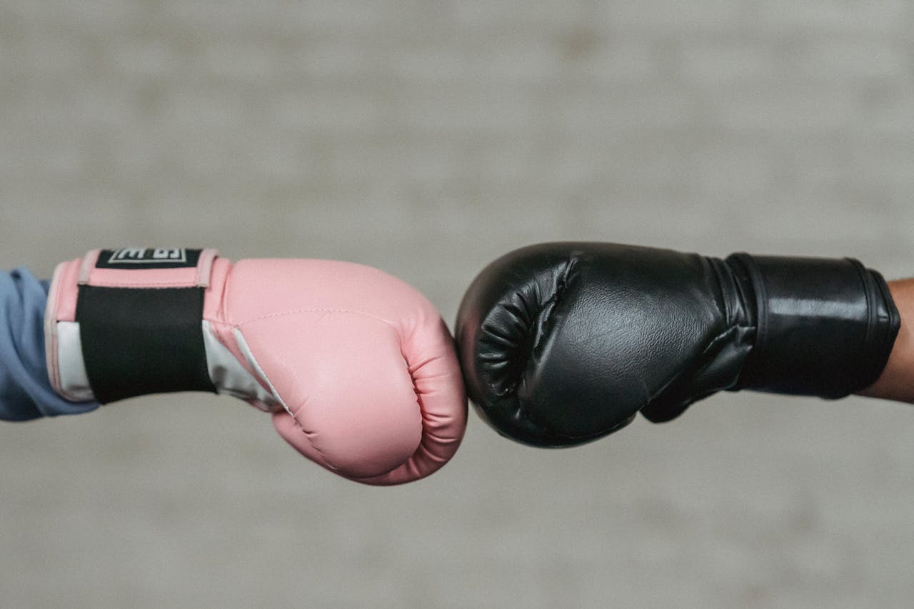 Deux boxeurs se tapant les poings avant un combat, illustrant le choix entre gestion autonome et gestion déléguée d’un compte-titres pour expatrié.