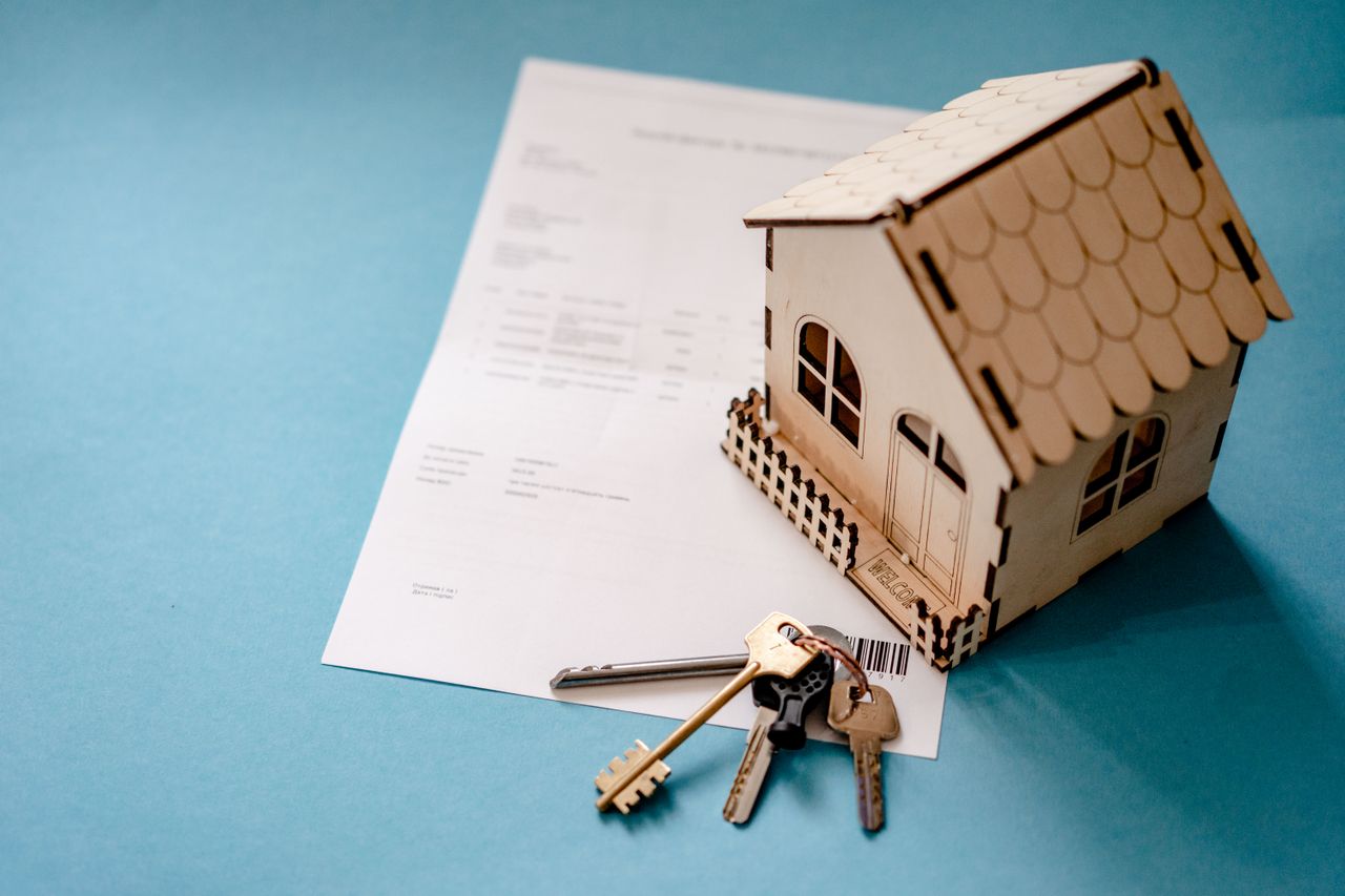 Maison miniature, clés et contrat illustrant le crédit lombard sur CTO pour expatrié