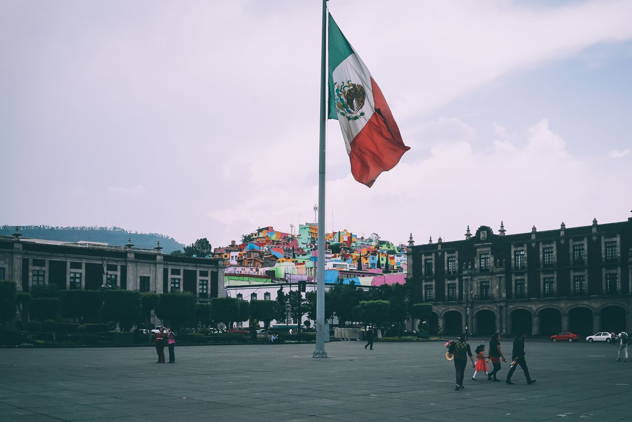 Personnes devant le drapeau mexicain illustrant la fiscalité d’un expatrié français au Mexique